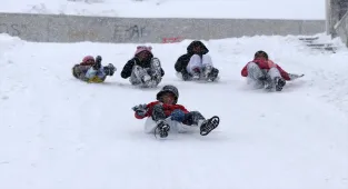 Sivas'ta çocuklar karda poşet ve tepsilerle kayarak yılbaşı tatilinin keyfini çıkardı